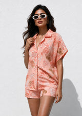Woman wearing a pink floral dress against a white background