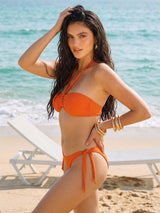 Woman in an orange bikini on a beach