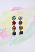 Set of Radiant Skies Earrings with colorful gemstones on a watercolor background