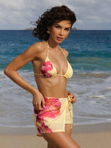 Woman in a floral bikini and cover-up on a beach