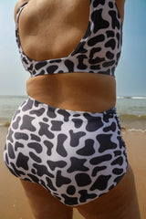 Woman wearing a cow print swimsuit