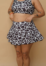 Woman wearing a black and white patterned top and skirt