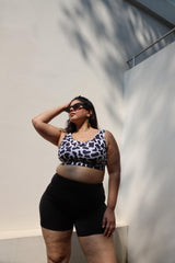 Woman wearing a cow print top and black shorts