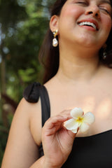 Woman holding a white flower in a round neck bikini top