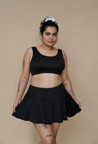 Woman wearing a black bikini top and skirt