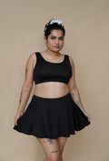 Woman wearing a black bikini top and skirt