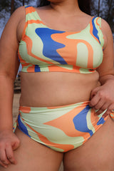 Curvy woman wearing a colorful swimsuit with abstract patterns