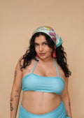 Woman wearing a blue bikini and colorful headscarf