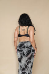 Plus size woman wearing a black bikini top and patterned skirt