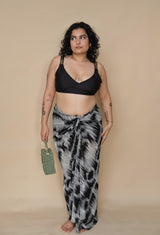 Woman wearing a black bikini top and patterned sarong