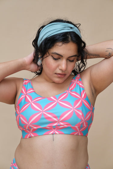 Woman wearing a pink and blue patterned round neck top