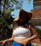 Woman wearing a wide-brimmed hat and white top