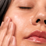 Close-up of a person's face with a hand gently touching the cheek.