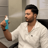 Man holding a blue bottle labeled 'Salutest' in an office setting