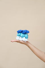 Hand holding three scrunchies
