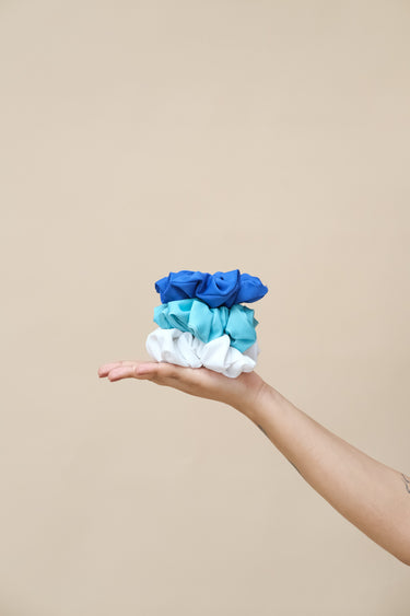 Hand holding three scrunchies