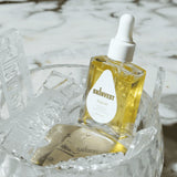 Skincare dropper bottle labeled 'skinvest' on a decorative stand with ice-like texture.