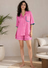 Woman wearing a pink pajama set in a living room setting
