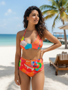 Woman in a colorful bikini standing on a beach with palm trees and ocean in the background