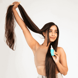 Woman with long hair holding a bottle of hair product against a white background