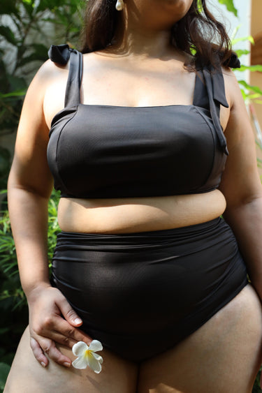 Plus size woman wearing a black bikini set