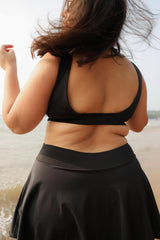 Curvy woman wearing a black top and skirt