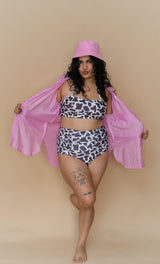Woman wearing a cow print bikini and pink cover-up 
