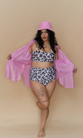 Woman wearing a cow print bikini and pink cover-up 