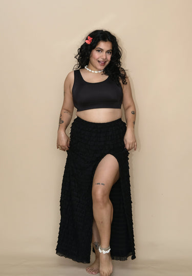 Woman wearing a black bikini top and a long skirt 