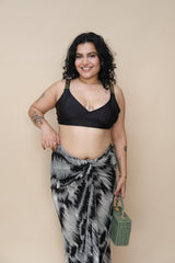 Woman wearing a black top and patterned skirt 