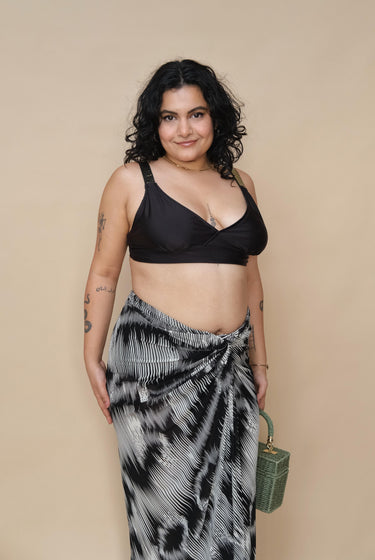 Woman wearing a black top and patterned skirt 