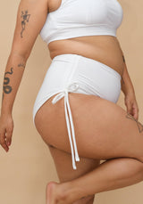 Curvy woman wearing a white bikini bottom