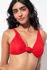 Woman wearing a red bikini top against a white background