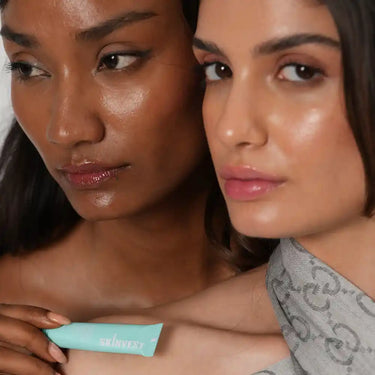 Two women holding a Skinvest product against a neutral background