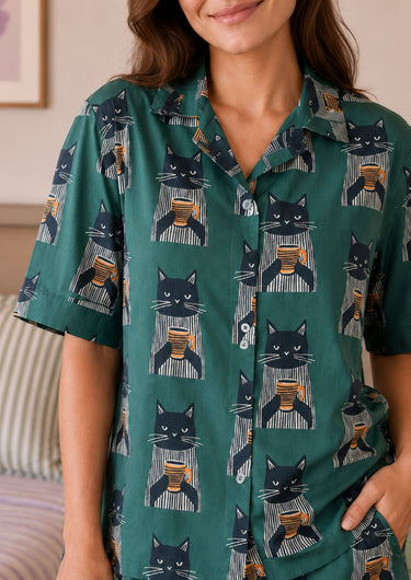 Person wearing a green shirt with cat and coffee pattern